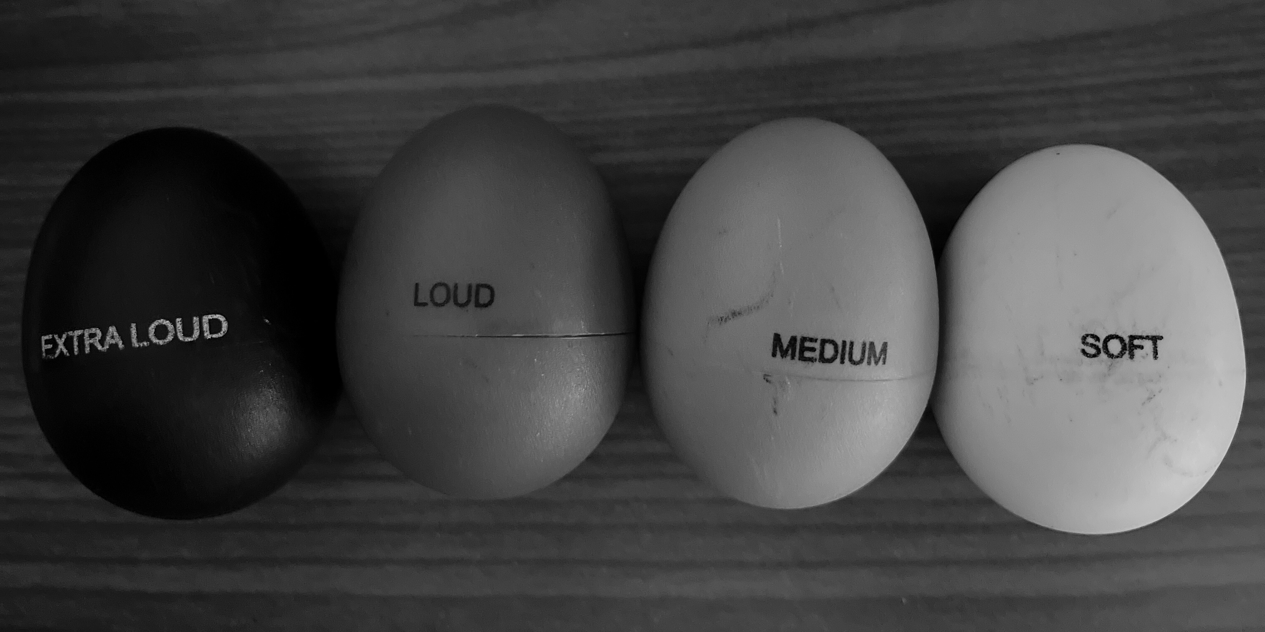 Black and white image of four shaker eggs next to each other with the words 