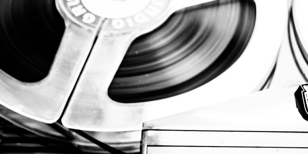 Black and white close-up image of a reel-to-reel tape machine by Markus Spiske from Pixabay